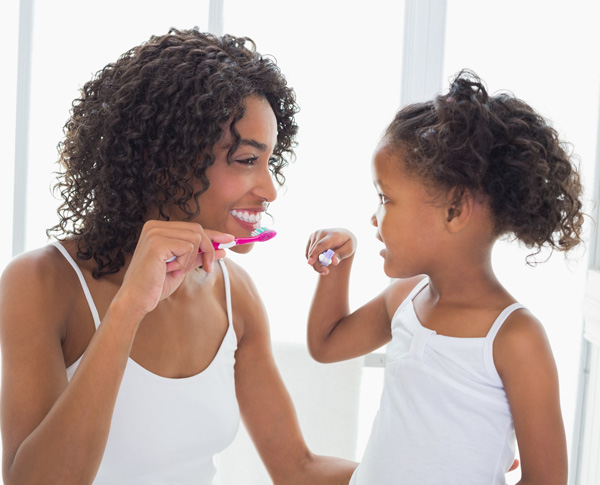mom daughter cleaning teeth