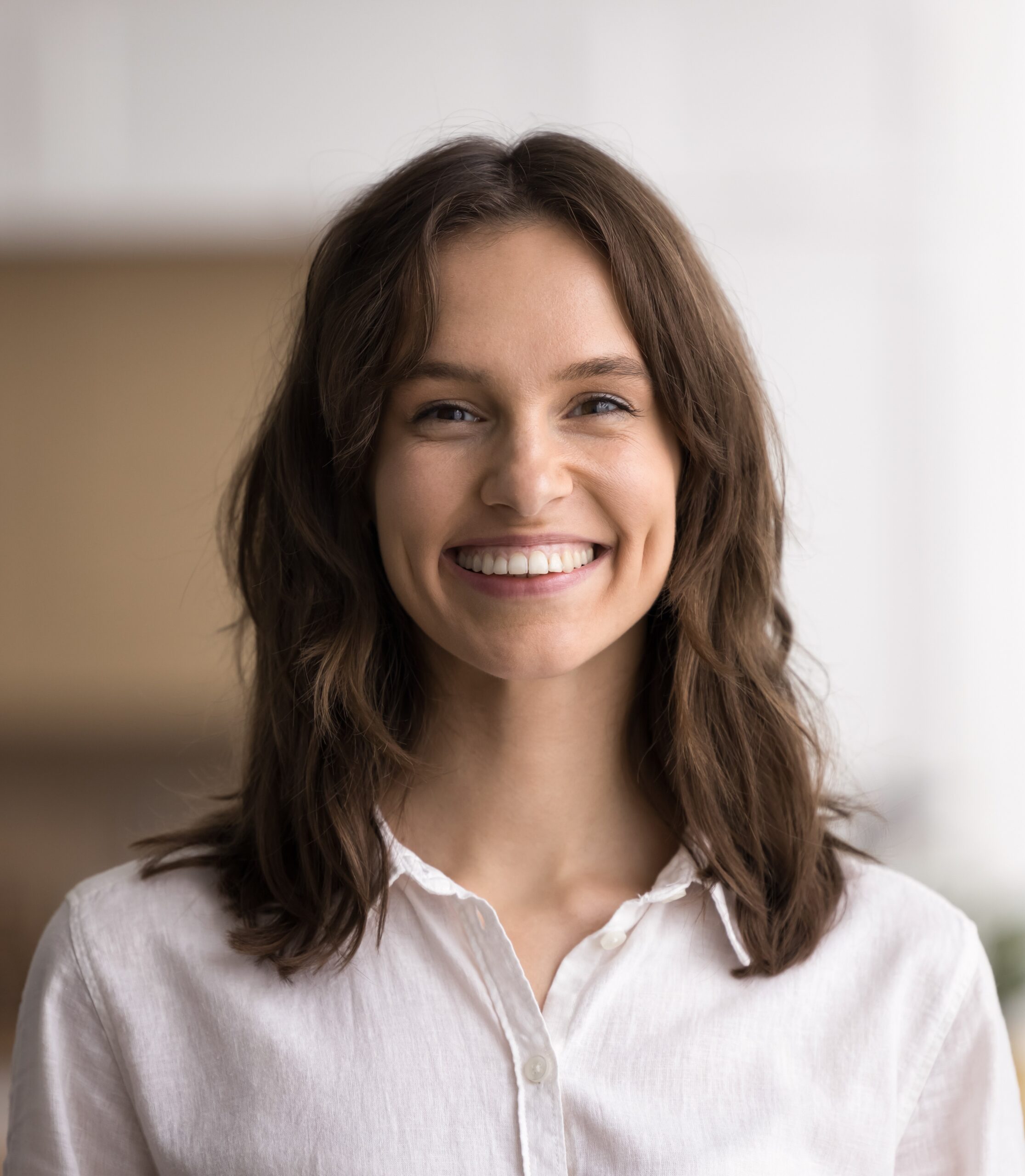 Headshot beautiful young woman looking at camera with white smile