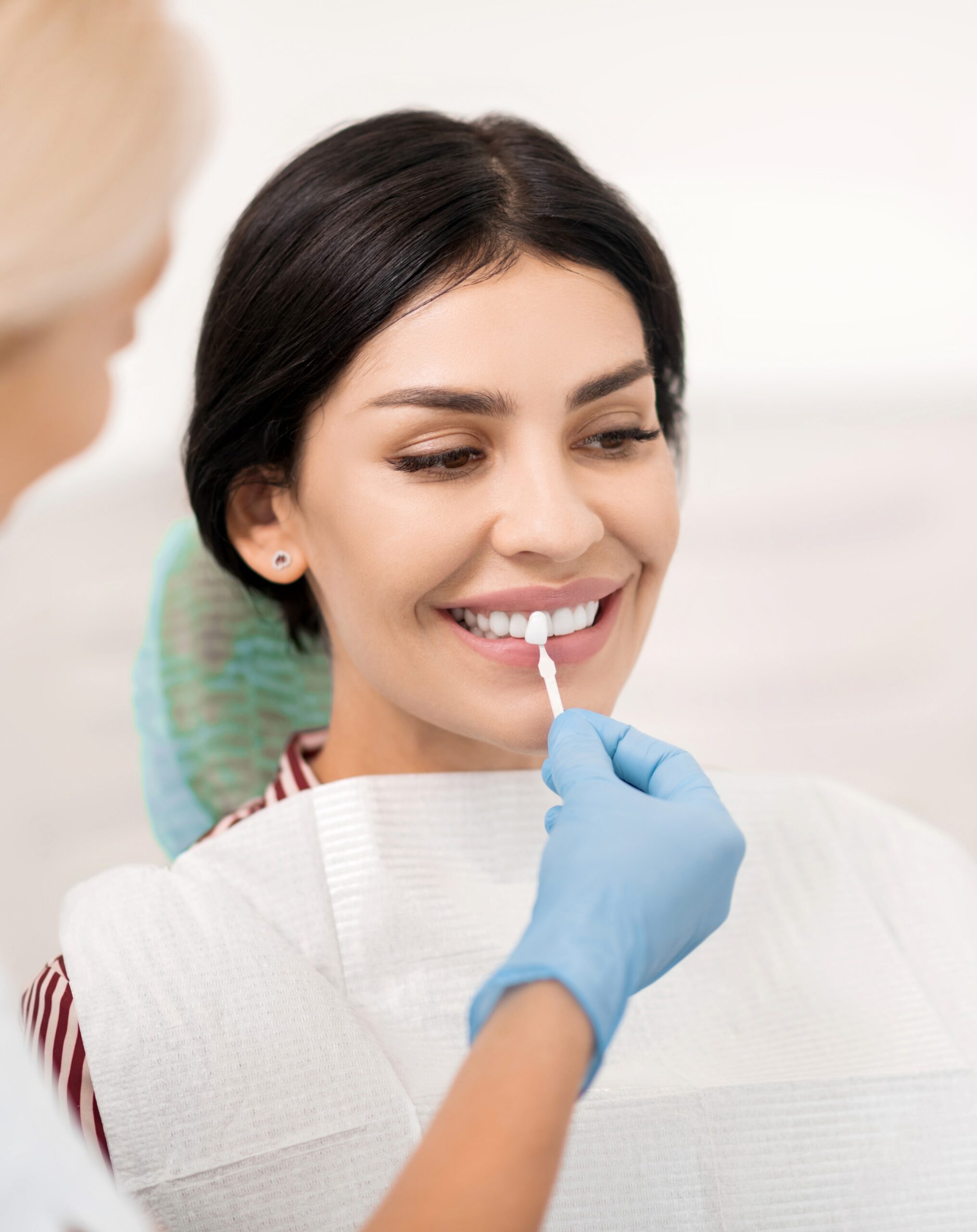 Woman trying on teeth whitening sample at dentists.