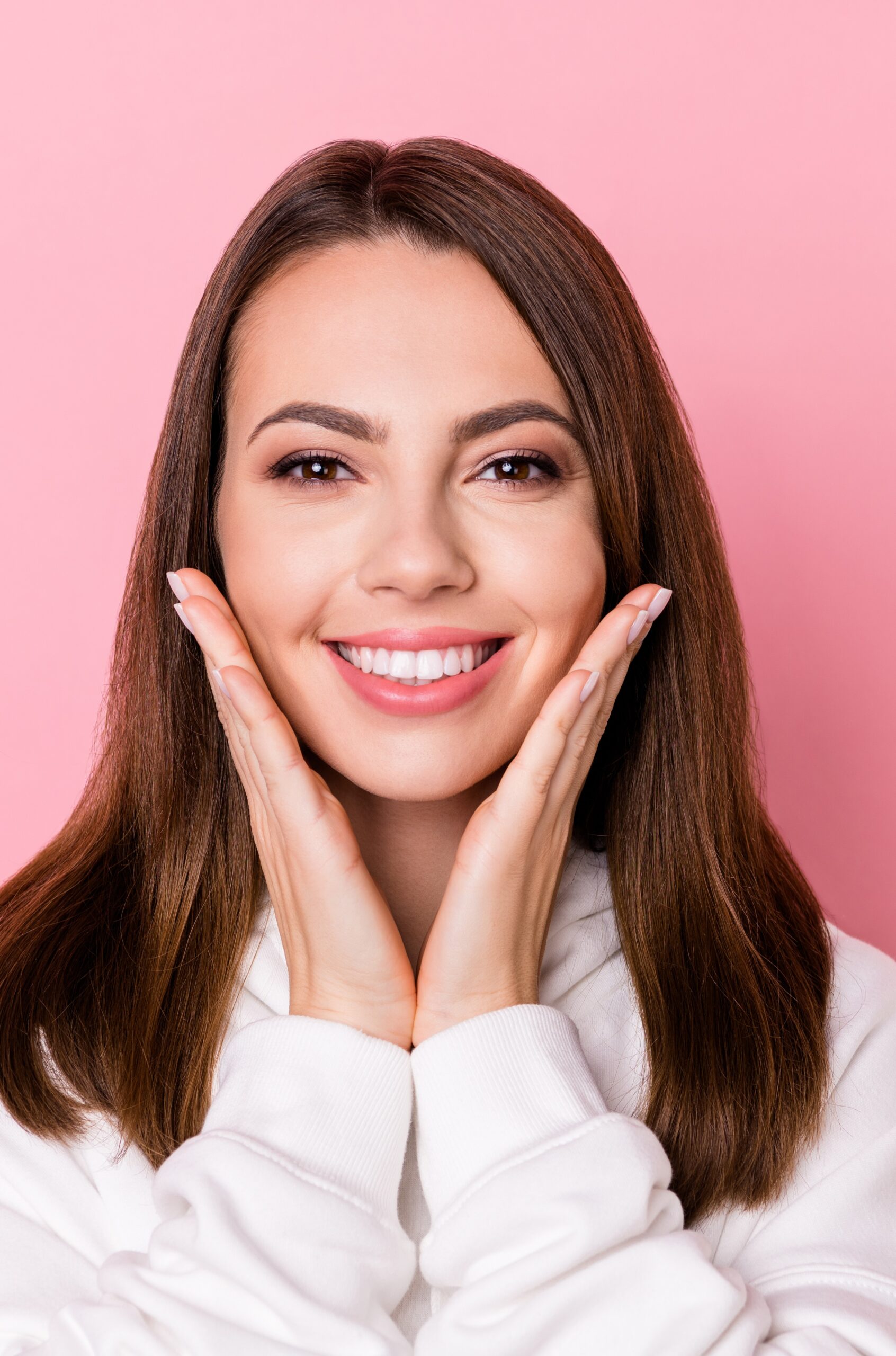 Photo of attractive happy young pretty woman hold hands face cheeks teeth isolated on pink color background