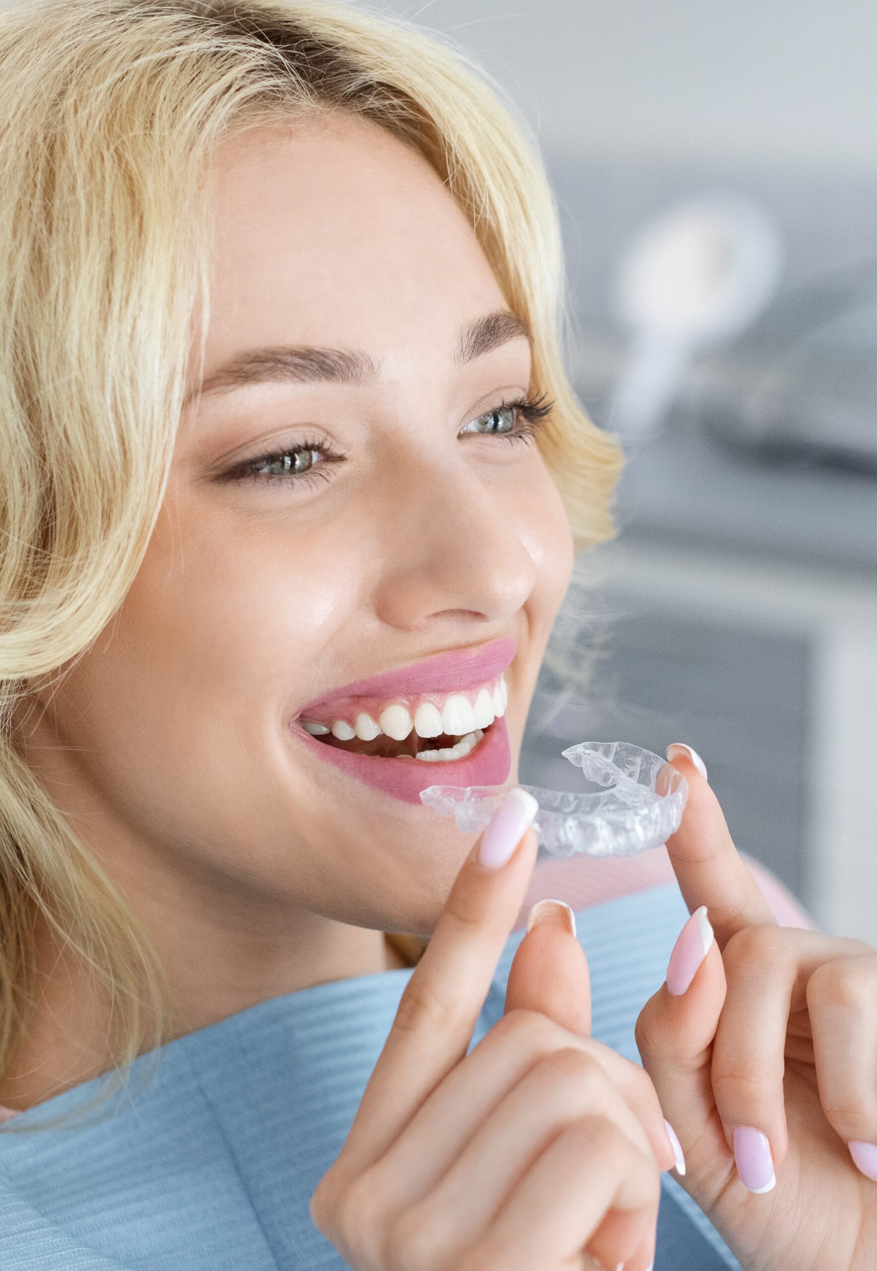 Young attractive woman holding invisible braces or trainer