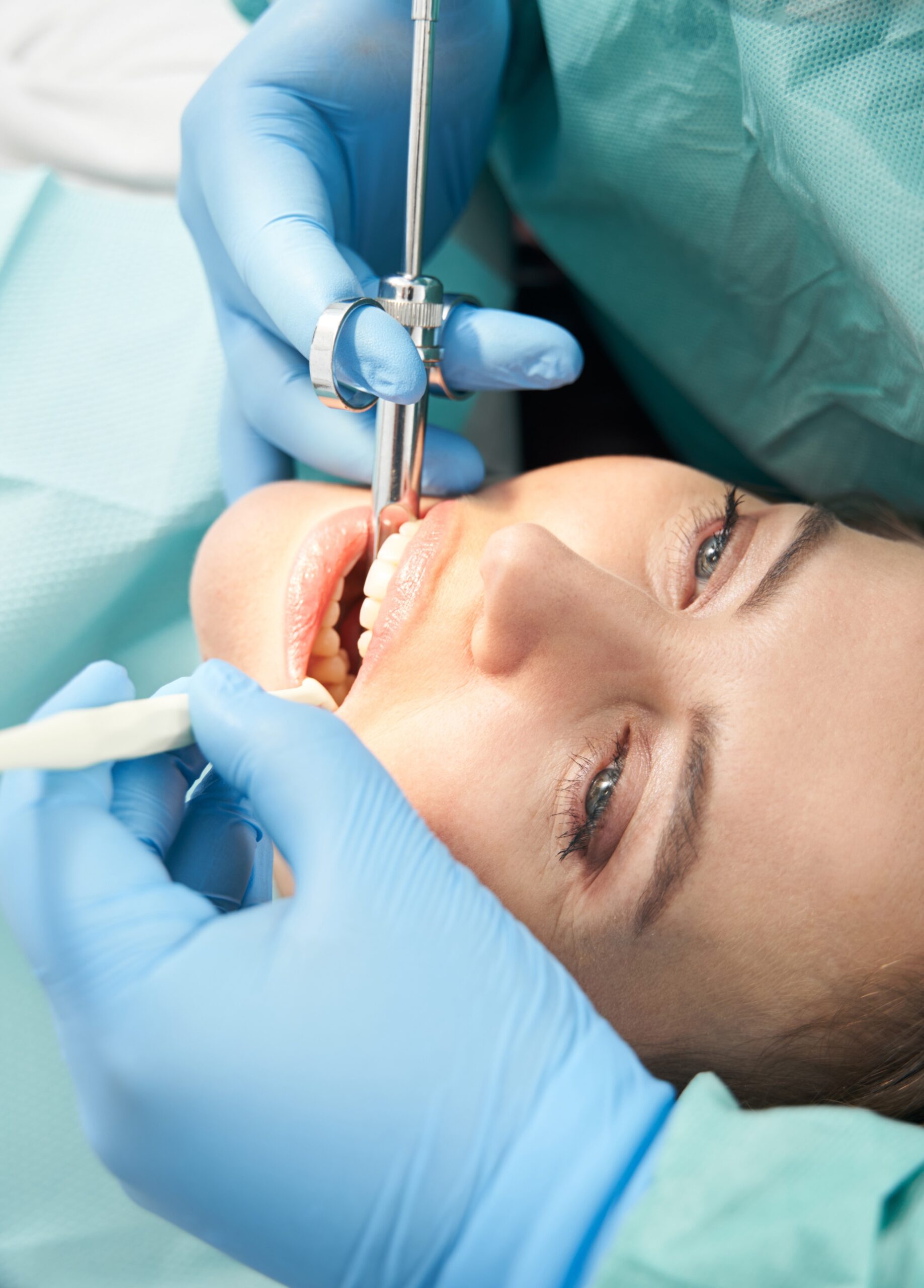 Close up of dentist hands in sterile gloves doing local anesthesia injection before dental procedure in stomatology clinic