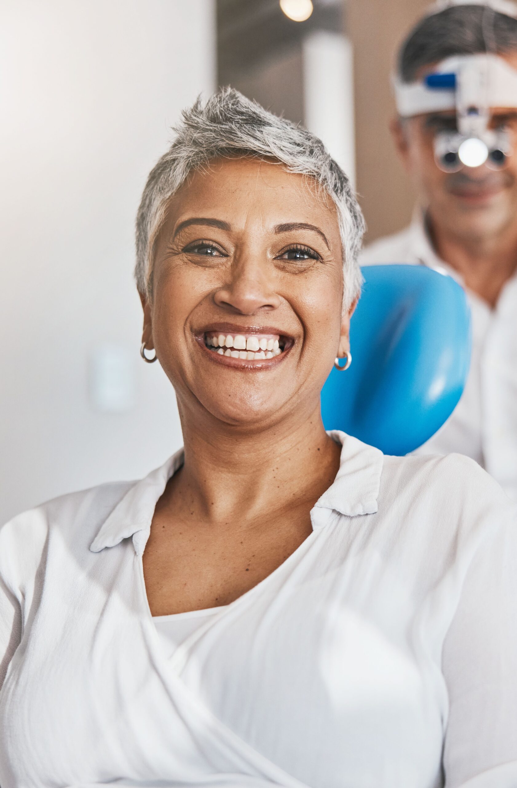 Portrait, happy and dental with a woman patient in a doctor office for oral hygiene or health. Smile, teeth and healthcare with a senior female sitting in a chair at the dentist for hygiene