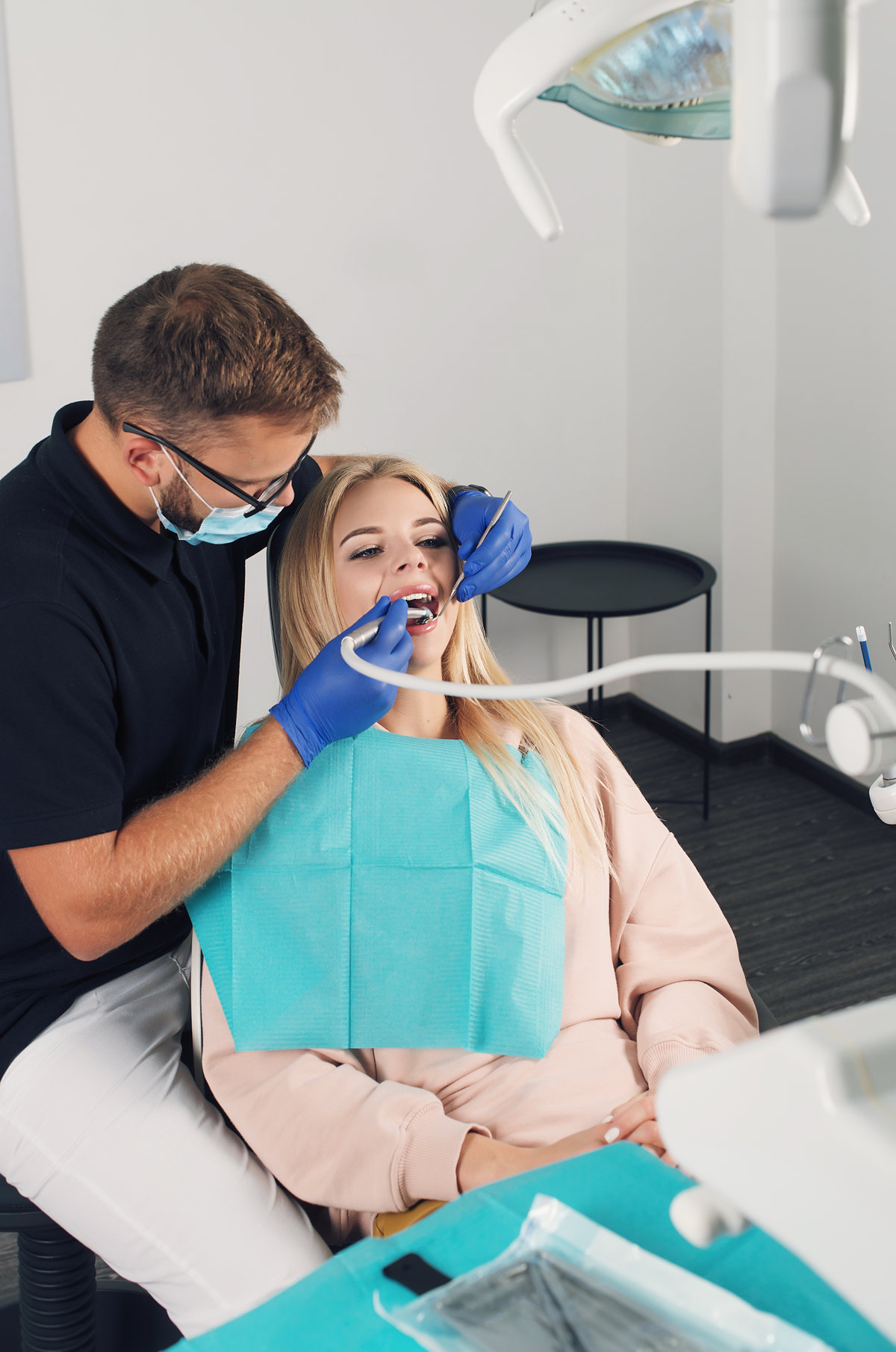 Portrait of a dentist who treats teeth of young woman patient.